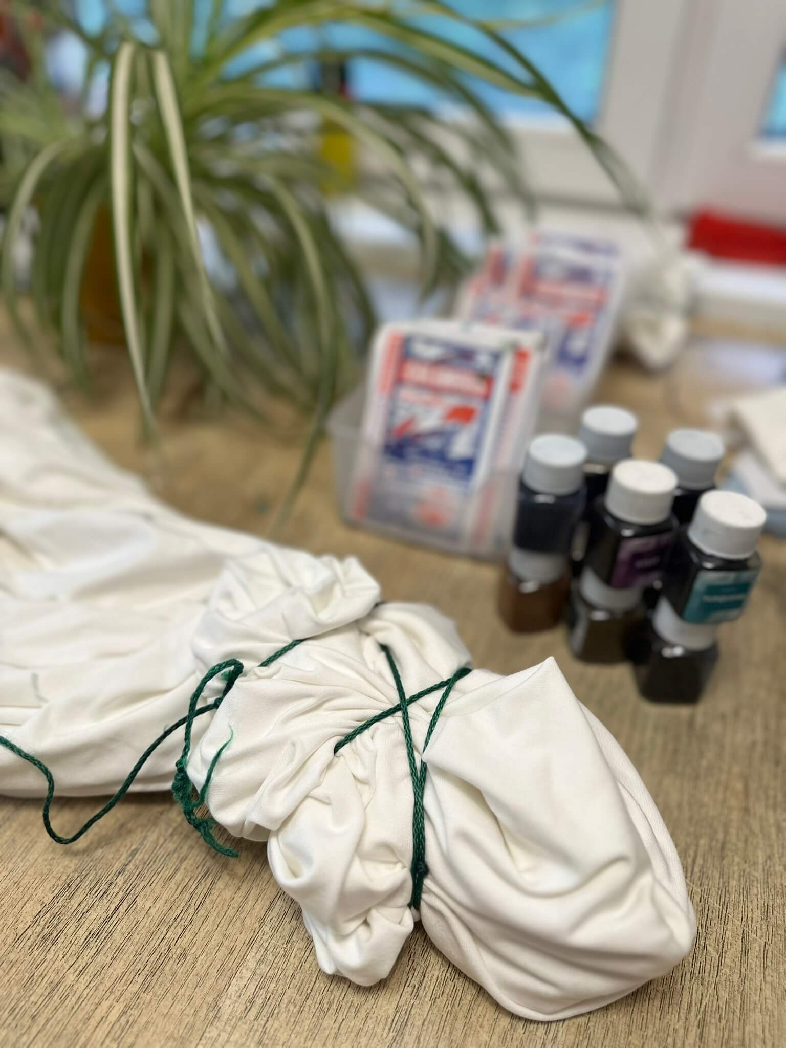 Batikolás — a megkötött fehér ruha a festékek mellett
